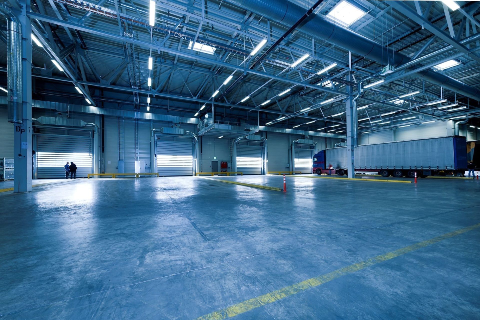 Grand entrepôt intérieur avec camions à quai, idéal pour la logistique et l'entreposage.